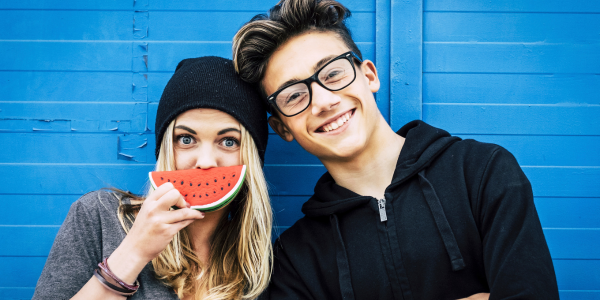 Girl with watermelon smile posing with boy