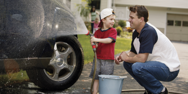 Dad washing car with kid