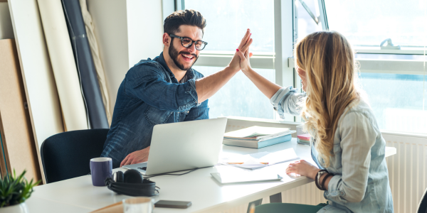 Small business owners hi-fiving at table