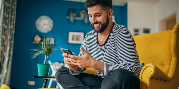 Man sitting on yellow chair using text banking